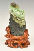 Chinese carved jade boulder with crab and flower decoration, on wooden stand, 22cm tall.