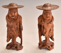 A pair of Chinese carved fruitwood figures of elderly gentlemen wearing hats, 12cm tall.