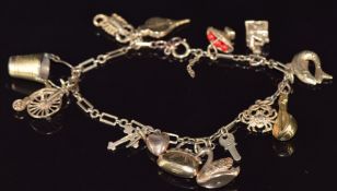 A 9ct gold charm bracelet with thirteen 9ct gold charms including swan, bag, crab, fish, scorpion,