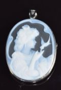 An 18ct white gold pendant / brooch set with a porcelain cameo depicting a lady with a bird, 3.5 x