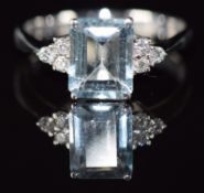 An 18ct white gold ring set with an emerald cut aquamarine and three diamonds to each shoulder, 2.