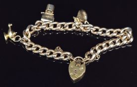 A gold plated charm bracelet with four 9ct gold charms and heart padlock clasp