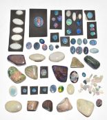 A collection of loose black and white opal cabochons including doublets and triplets