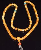 A 19thC strand of amber prayer beads with turquoise, coral and white metal beads, 39.4g