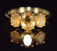 A 9ct gold ring set with three oval citrines, 2.3g, size N