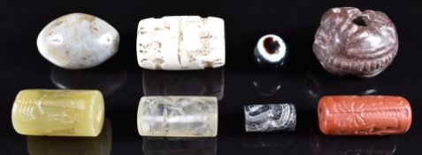 A collection of beads including a carved rock crystal intaglio example, intaglio banded agate and