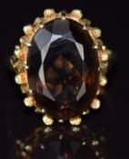 A 14k gold ring set with an oval smoky quartz, 7.6g, size N