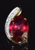 A 9ct gold pendant set with an oval cut red topaz and round cut white topaz, 1.8cm, 3.7g