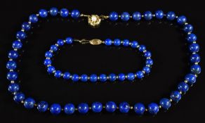 A necklace of lapis lazuli beads interspersed with gold beads, the 9ct gold clasp set with a