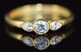 An 18ct gold ring set with a round cut diamond of approximately 0.18ct and two pear cut diamonds,