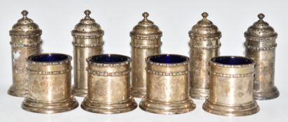 George V hallmarked silver cruet set comprising four open salts with blue glass liners and five