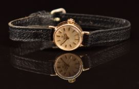 Omega 9ct gold ladies wristwatch with gold hands and baton hour markers, cream dial and signed 17