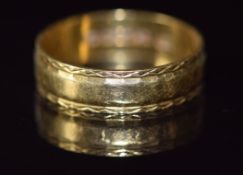 An 18ct gold wedding band / ring with engraved borders, 3.4g, size O