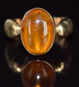 A 9ct gold ring set with a pressed amber cabochon, 4.6g, size M/N