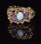 A 9ct gold ring set with garnets and an opal in a rope twist setting, 4.7g, size L