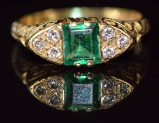 An 18ct gold ring set with an emerald cut emerald of approximately 0.5ct and three diamonds to