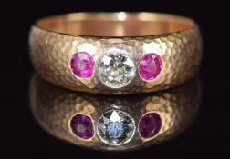 A 9ct gold ring with hammered decoration set with an old cut diamond of approximately 0.25ct and two