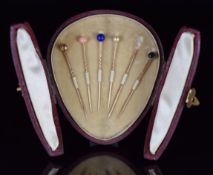 Victorian yellow metal stick pins set with coral, lapis lazuli, pearl and cat's eye chalcedony, in