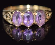 A 9ct gold ring set with three oval cut amethysts, 1.5g, size M/N