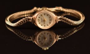 Garrard 9ct gold ladies wristwatch with gold hands and hour markers and silver dial, on 9ct gold