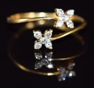An 18ct gold ring set with diamonds in two flower clusters, 1.5g, size M
