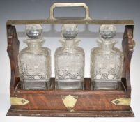 Oak three bottle tantalus with silver plated mounts, W37 x H32cm