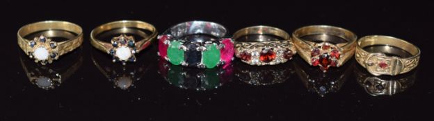 Six silver rings including opal and sapphire set, buckle ring, garnet and sapphire, emerald and ruby