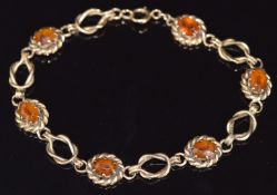 A 9ct gold bracelet set with oval cut citrines and knotted links, 13g, 20cm long
