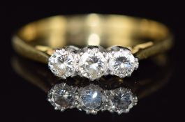 An 18ct gold ring set with three diamonds, the centre diamond of approximately 0.2ct, 2.6g, size T