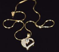 An 18ct gold heart pendant set with round and baguette cut diamonds, total diamond weight approx 0.