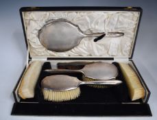 Cased Art Deco hallmarked silver dressing table set, comprising hand mirror, four brushes and