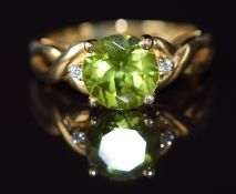 A 9ct gold ring set with a round cut peridot and diamonds, 2.5g, size J