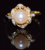 An 18k gold ring set with a pearl and diamonds in a pierced setting, 3.2g, size L