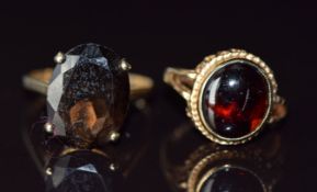 Two 9ct gold rings, one set with a garnet cabochon the other a smoky quartz, 7.6g, size H & R
