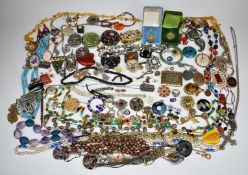 A collection of costume jewellery including beads, vintage brooches, silver pendant, glass beads,