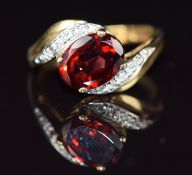 A 9ct gold ring set with a garnet and diamonds, 2.4g, size J