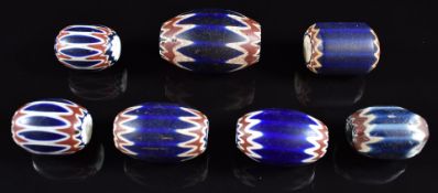 Seven 19thC Venetian glass six layered blue, red and white chevron trade beads, largest 4cm