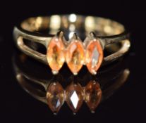 A 9ct gold ring set with three marquise cut orange sapphires, 2.6g, size N