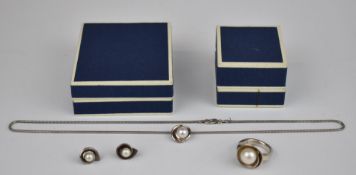 A suite of silver jewellery comprising ring, earrings and necklace set with pearls