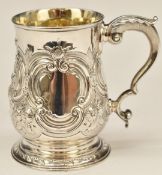 Georgian hallmarked silver pint tankard with embossed decoration and scrolling handle, London