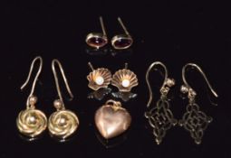 Four pairs of earrings including one pair set with garnets and another in the form of a shell set
