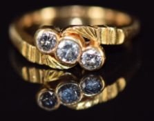 An 18ct gold ring set with three diamonds in a twist setting, 3.8g, size G