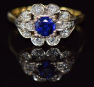 An 18ct gold ring set with a round cut sapphire of approximately 0.5ct and diamonds in a platinum