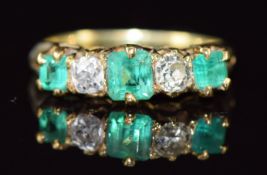 Victorian 18ct gold ring set with emerald cut emeralds, the largest approximately 0.4ct and old