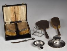 Hallmarked silver capstan inkwell with pen rest indent to lid, hallmarked silver toast rack,