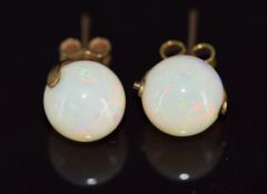 A pair of 9ct gold earrings set with opal spheres, 2.6g