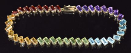 A 9ct gold bracelet set with emerald cut garnets, citrines, peridot, topaz and amethysts, 7.8g, 18cm