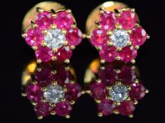 A pair of 14k gold earrings set with a diamond surrounded by rubies in a cluster, 3.7g