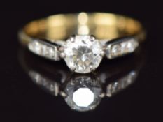 An 18ct gold ring set with a diamond of approximately 0.5ct in a platinum setting with further