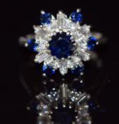 An 18ct white gold ring set with round cut sapphires and round and baguette cut diamonds, 5.2g, size